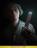 An old woman with short grey hair wearing working clothes. Half of her face is in shadow, and the other half is illuminated by the glow of the cattle-prod-like device she holds up in her left hand.
